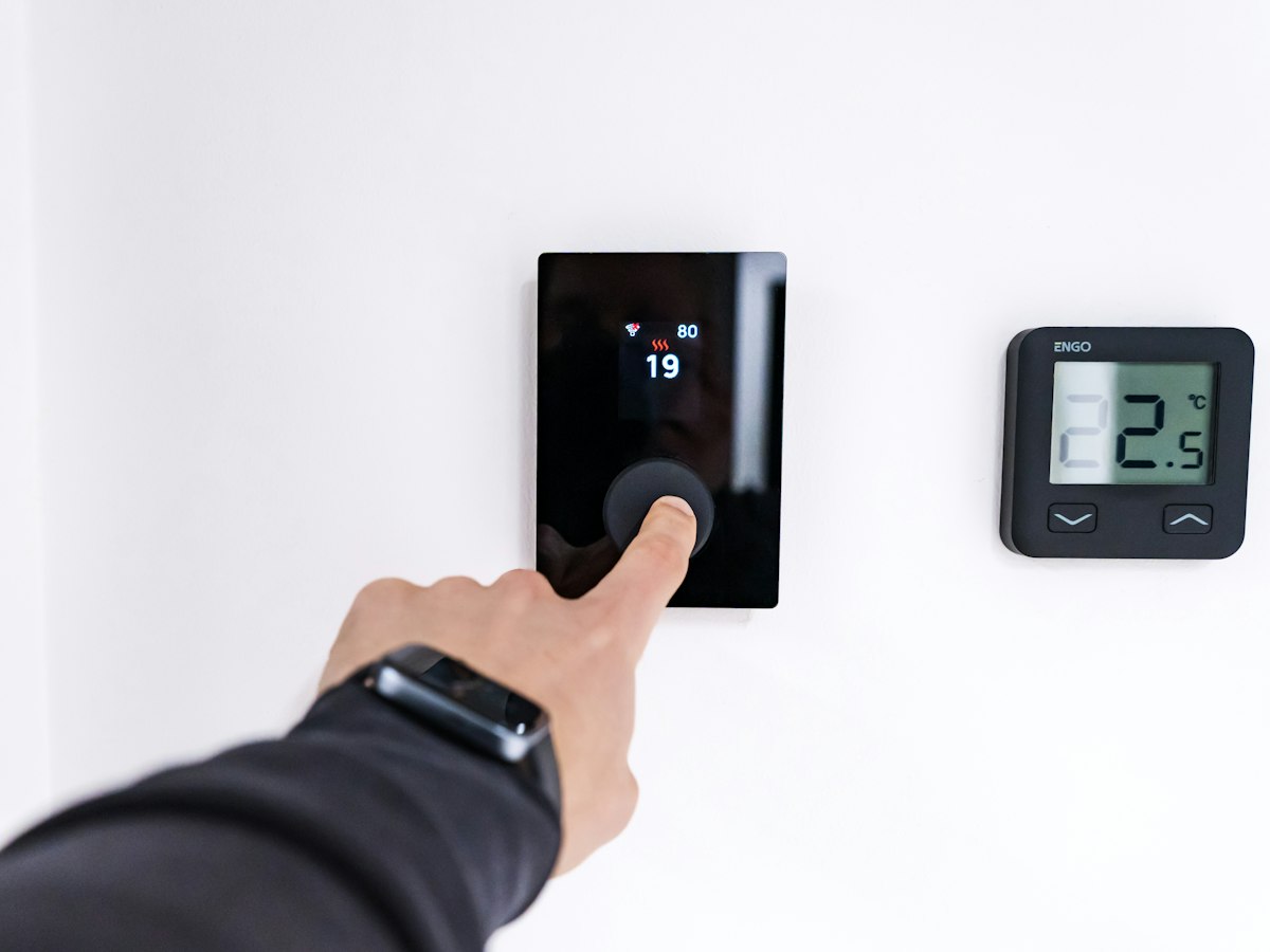 A homeowner adjusting their smart thermostat